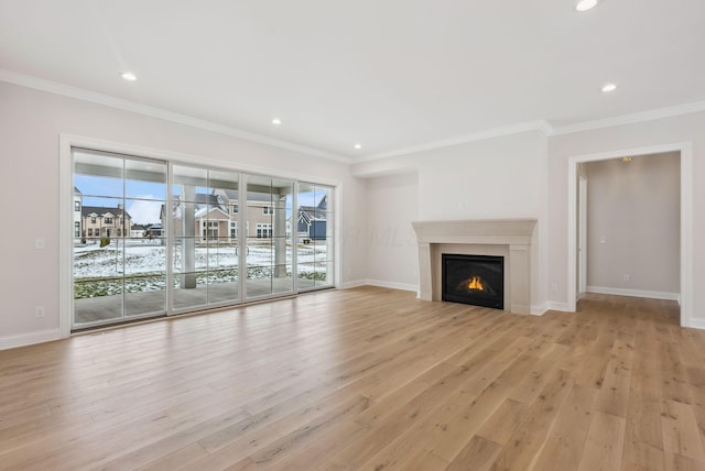 unfurnished living room with plenty of natural light, light hardwood / wood-style flooring, and ornamental molding