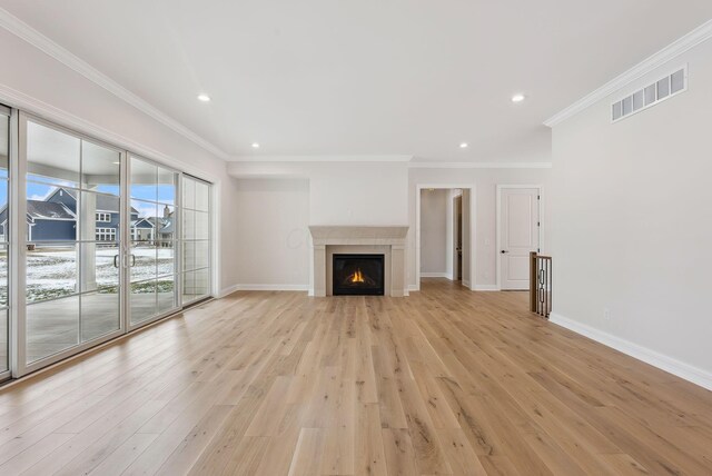 unfurnished living room with crown molding and light wood-type flooring