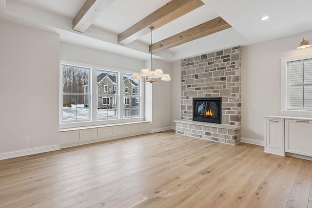 unfurnished living room with light hardwood / wood-style flooring, beamed ceiling, and a fireplace