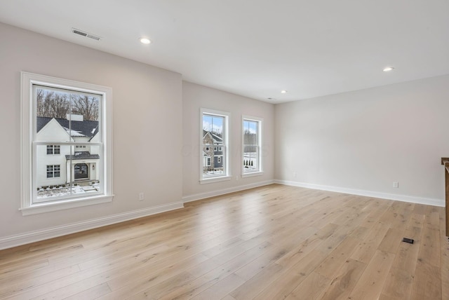 unfurnished room with light hardwood / wood-style floors and a healthy amount of sunlight