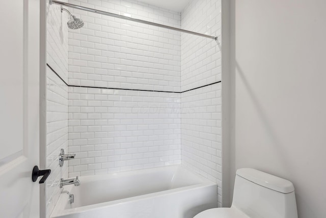 bathroom featuring toilet and tiled shower / bath combo