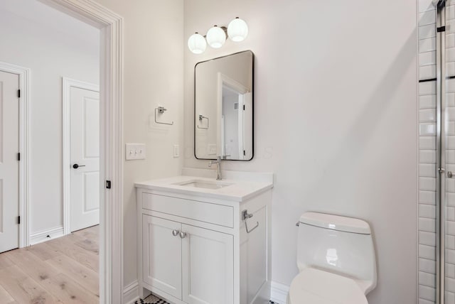 bathroom with hardwood / wood-style floors, toilet, and vanity