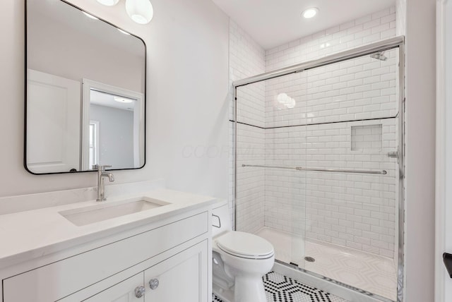 bathroom with an enclosed shower, vanity, and toilet