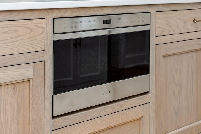 interior details with light brown cabinets and oven