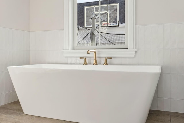 bathroom featuring a washtub and tile patterned floors