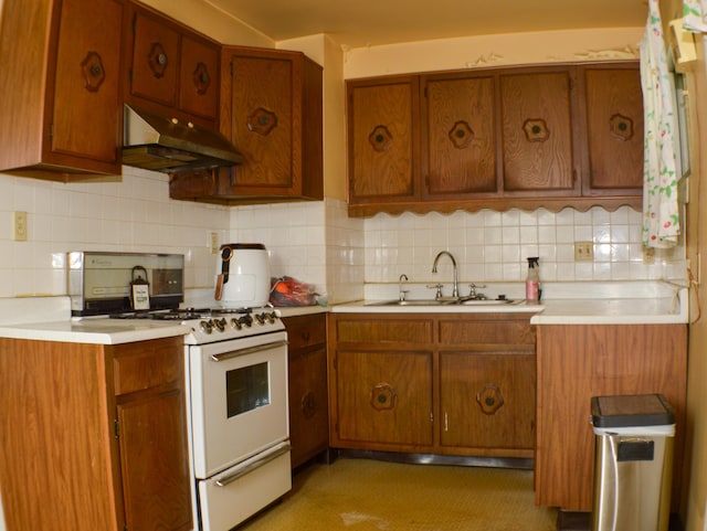 kitchen featuring white range with gas stovetop, backsplash, and sink