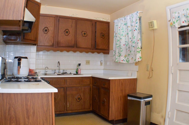 kitchen with gas cooktop, backsplash, and sink