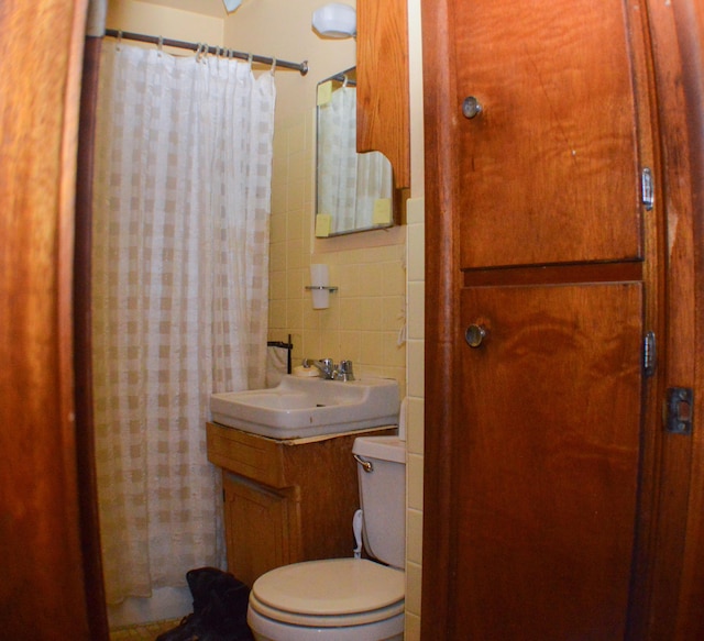 bathroom with vanity, tile walls, and toilet