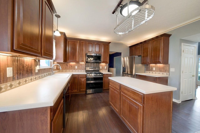 kitchen featuring a sink, light countertops, appliances with stainless steel finishes, a center island, and dark wood finished floors