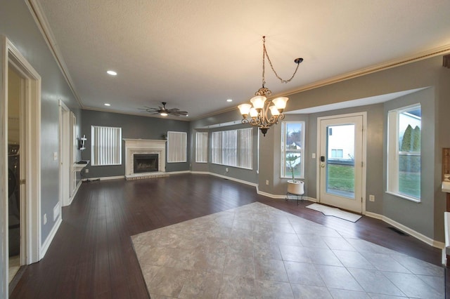 unfurnished living room with baseboards, ornamental molding, dark wood-type flooring, a brick fireplace, and recessed lighting