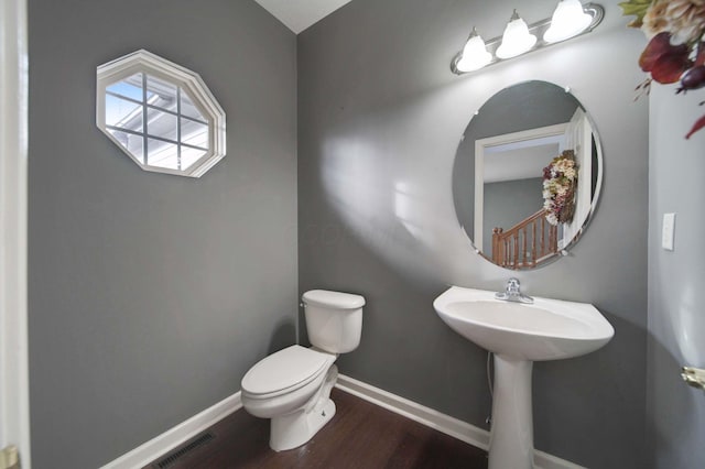 bathroom featuring toilet, baseboards, and wood finished floors