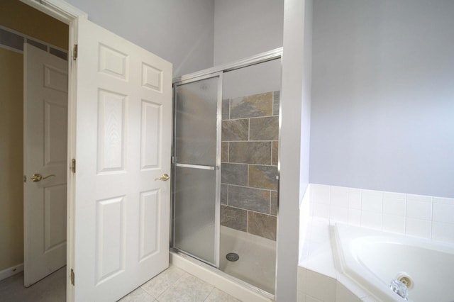 bathroom with a garden tub, tile patterned flooring, and a shower stall