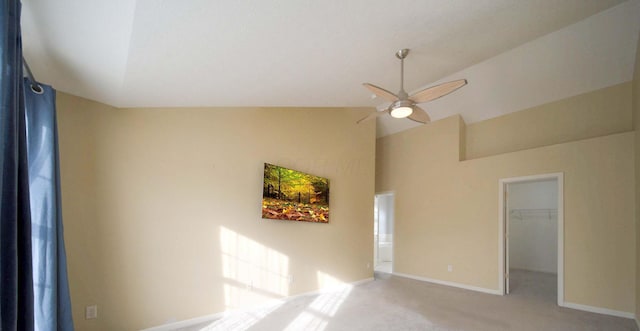 spare room featuring lofted ceiling, carpet, a ceiling fan, and baseboards