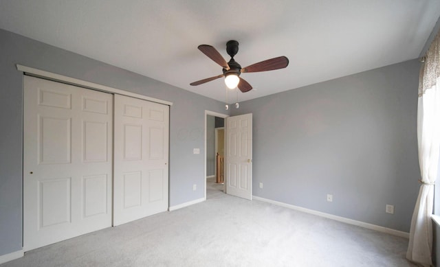 unfurnished bedroom with a ceiling fan, baseboards, a closet, and light colored carpet