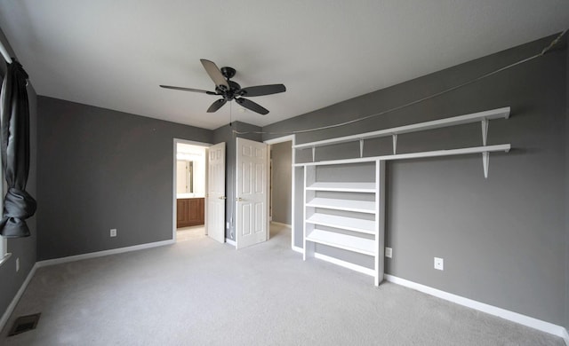 unfurnished bedroom featuring light carpet, baseboards, visible vents, ceiling fan, and ensuite bathroom