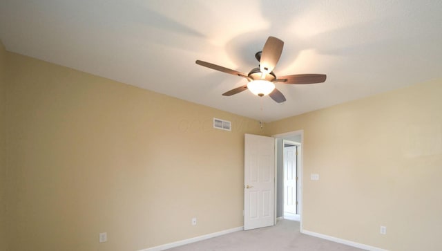 empty room with light carpet, ceiling fan, visible vents, and baseboards