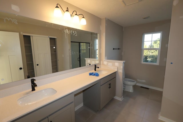 full bathroom featuring double vanity, a sink, toilet, and a shower stall