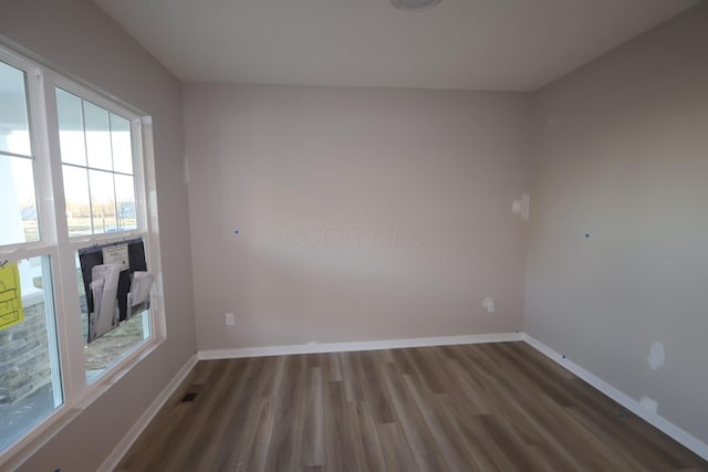 empty room with visible vents, baseboards, and wood finished floors