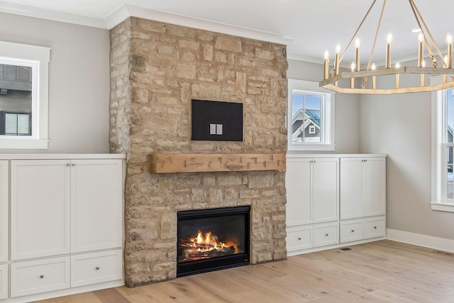 unfurnished living room featuring crown molding, a stone fireplace, and light hardwood / wood-style floors