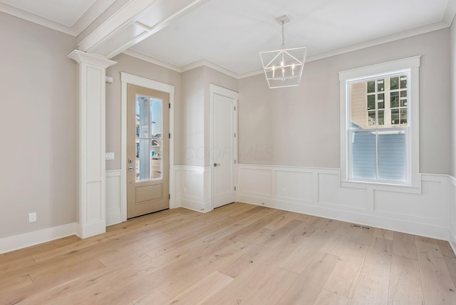 interior space featuring ornate columns, ornamental molding, light hardwood / wood-style floors, and a notable chandelier