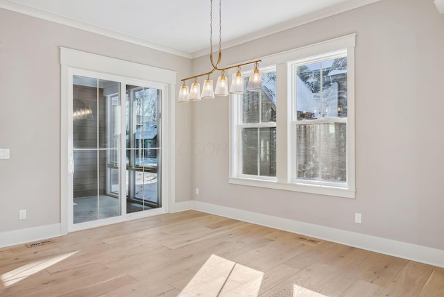 unfurnished dining area with ornamental molding, light hardwood / wood-style floors, and a notable chandelier