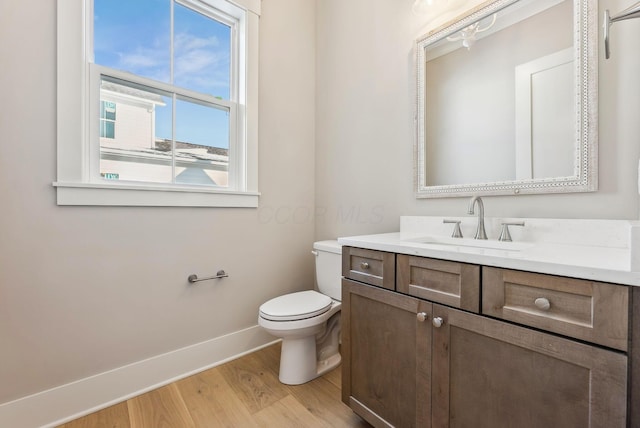 bathroom with toilet, wood-type flooring, and vanity