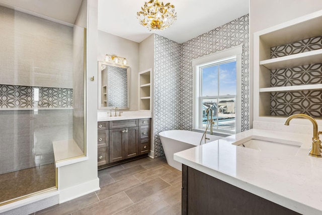 bathroom with a bath, an inviting chandelier, and vanity