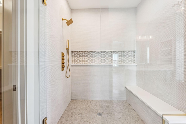 bathroom featuring tile walls and a tile shower