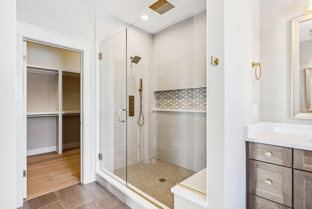 bathroom featuring tile patterned floors, an enclosed shower, and vanity