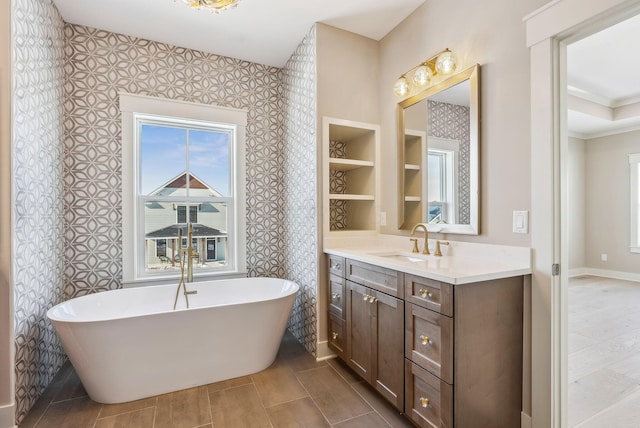 bathroom with ornamental molding, built in features, a bathing tub, and vanity