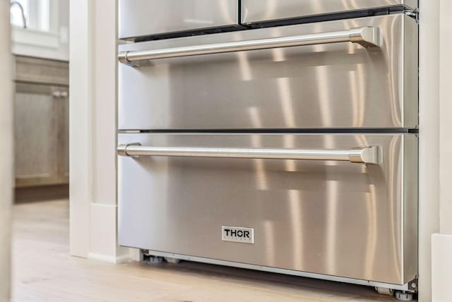 interior details with stainless steel double oven and light wood-type flooring