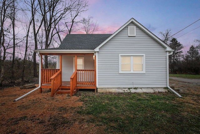 back house at dusk with covered porch