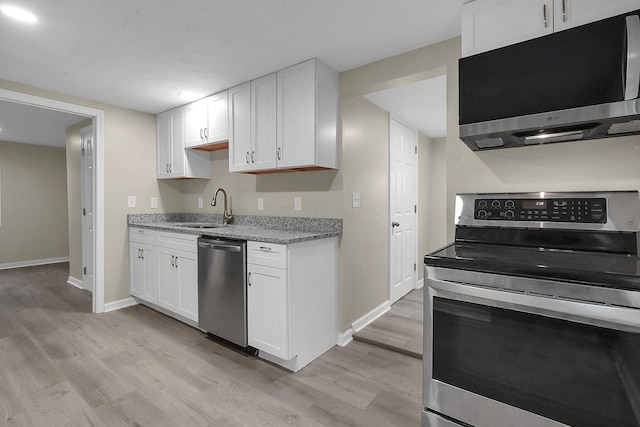 kitchen featuring appliances with stainless steel finishes, light wood-type flooring, white cabinetry, and sink