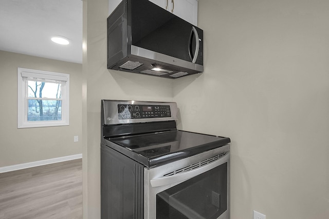 kitchen with stainless steel appliances and hardwood / wood-style flooring