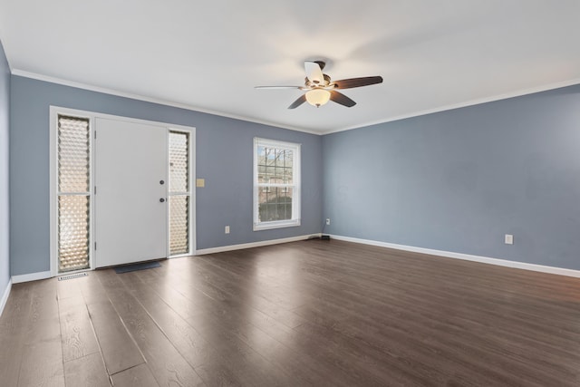 spare room featuring ceiling fan, baseboards, dark wood finished floors, and crown molding