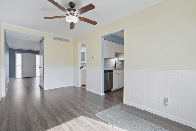 unfurnished living room featuring dark wood-style floors, a wainscoted wall, and visible vents