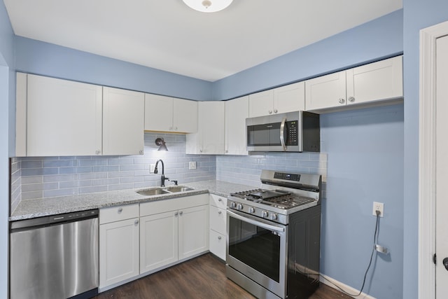 kitchen with appliances with stainless steel finishes, white cabinets, and a sink