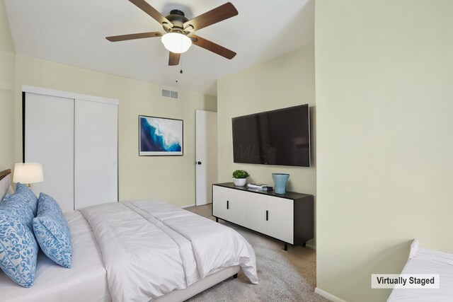 bedroom featuring light carpet, baseboards, visible vents, ceiling fan, and a closet