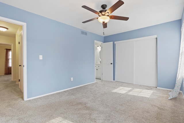 unfurnished bedroom with carpet, a closet, visible vents, and baseboards