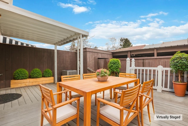 wooden terrace featuring outdoor dining area and fence