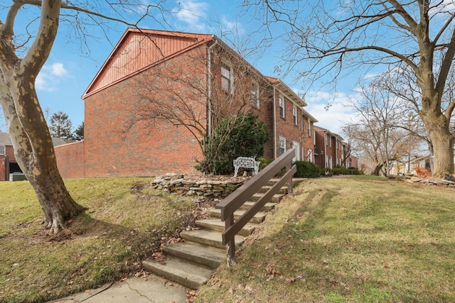 view of side of property featuring a yard and brick siding