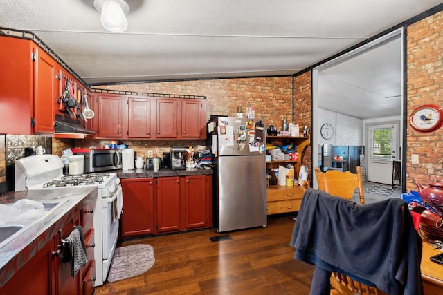 kitchen with stainless steel appliances, dark hardwood / wood-style flooring, brick wall, backsplash, and exhaust hood