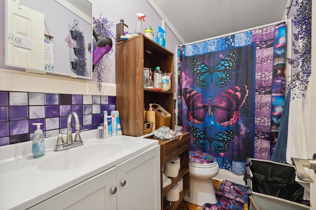 bathroom with vanity, a textured ceiling, backsplash, and toilet