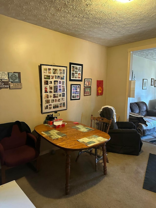 dining space with carpet and a textured ceiling