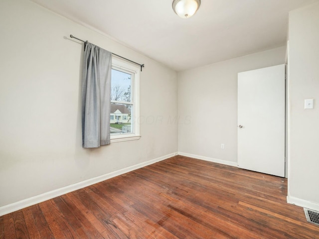 spare room with dark wood-type flooring