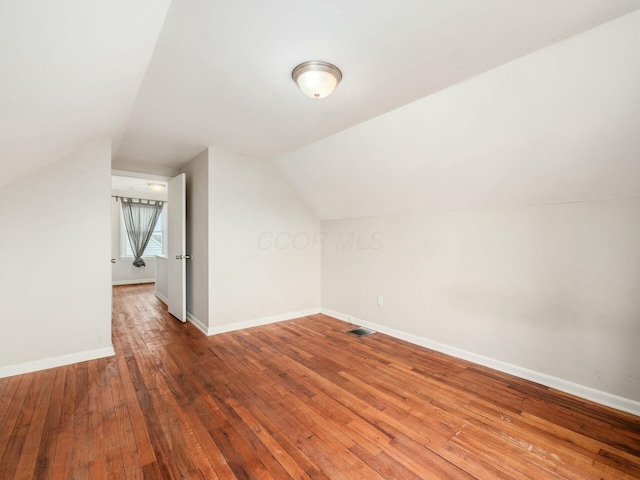 additional living space featuring hardwood / wood-style flooring and vaulted ceiling