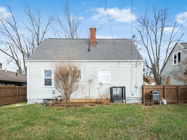 back of house with central AC unit and a lawn