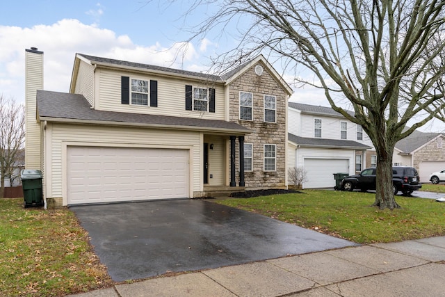 view of property with a garage and a front lawn