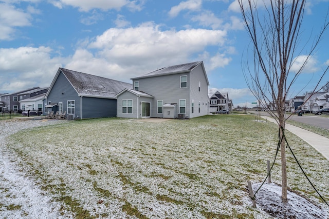 back of property featuring central AC and a lawn