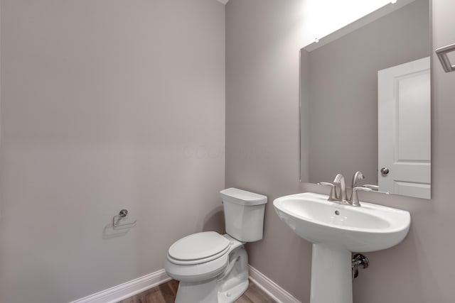 bathroom with toilet and wood-type flooring